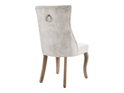 Conjunto de 4 sillas de terciopelo beige claro con patas de madera curvadas y botones decorativos.