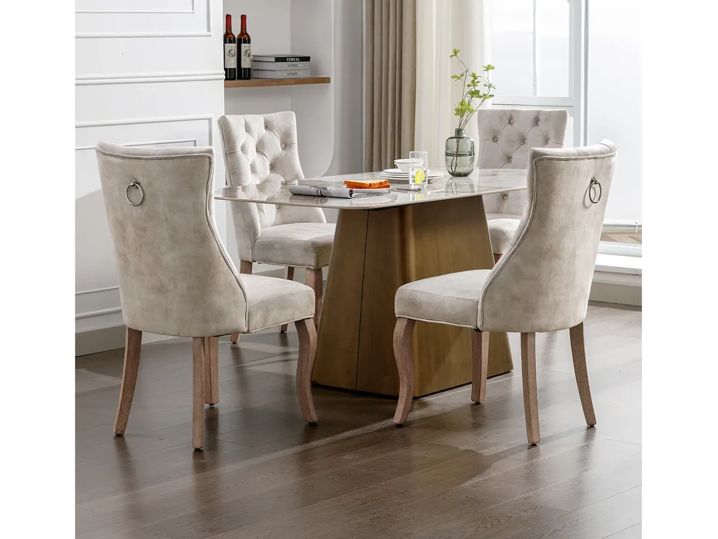 Conjunto de 4 sillas de terciopelo beige claro con patas de madera curvadas y botones decorativos.