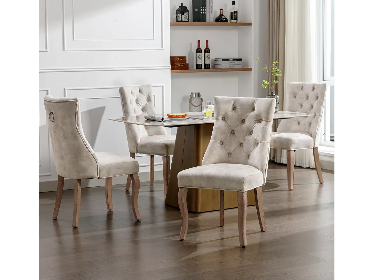 Conjunto de 4 sillas de terciopelo beige claro con patas de madera curvadas y botones decorativos.