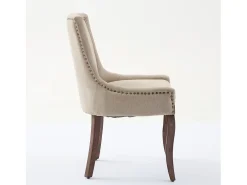 Juego de 2 sillas beige con patas de madera curvadas y ribete de tachuelas.