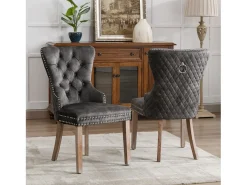 Juego de 2 sillas de cocina de terciopelo gris con detalles en tachuelas plateadas y patas de madera marrón.